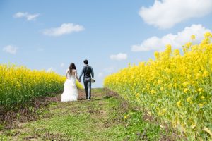 ロケーションフォトウェディング　洋装　ウェディングドレス　タキシード　バックショット　菜の花畑