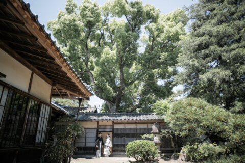 新潟県聖籠町の二宮家バラ園内日本庭園で撮影した和装ウェディングフォト。自然光に包まれた庭園で白無垢と紋付袴を着た新郎新婦