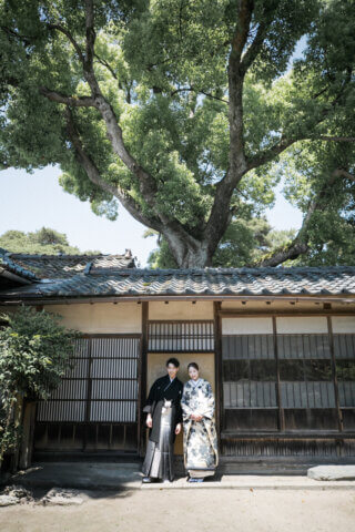 新潟県聖籠町の二宮家バラ園内日本庭園で撮影した和装ウェディングフォト。自然光に包まれた庭園で白無垢と紋付袴を着た新郎新婦