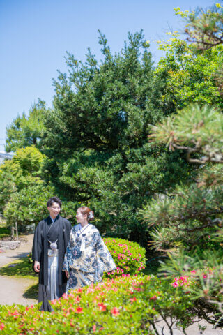 新潟県聖籠町の二宮家バラ園内日本庭園で撮影した和装ウェディングフォト。自然光に包まれた庭園で白無垢と紋付袴を着た新郎新婦
