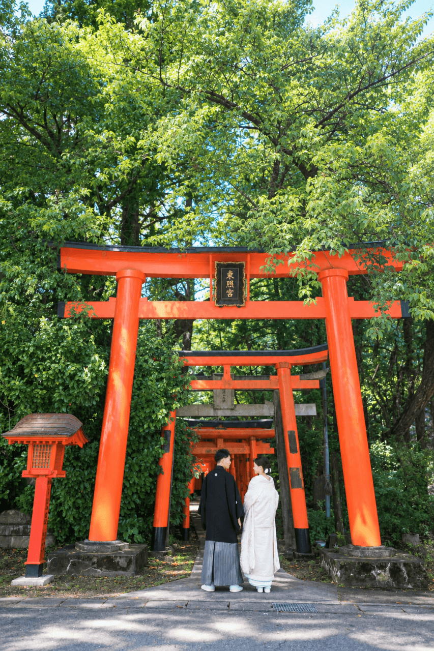 新発田の大友稲荷奥之院で朱色の鳥居を歩く白無垢の花嫁と紋付袴の花婿