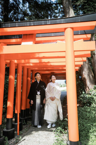 新発田の大友稲荷奥之院で朱色の鳥居を歩く白無垢の花嫁と紋付袴の花婿