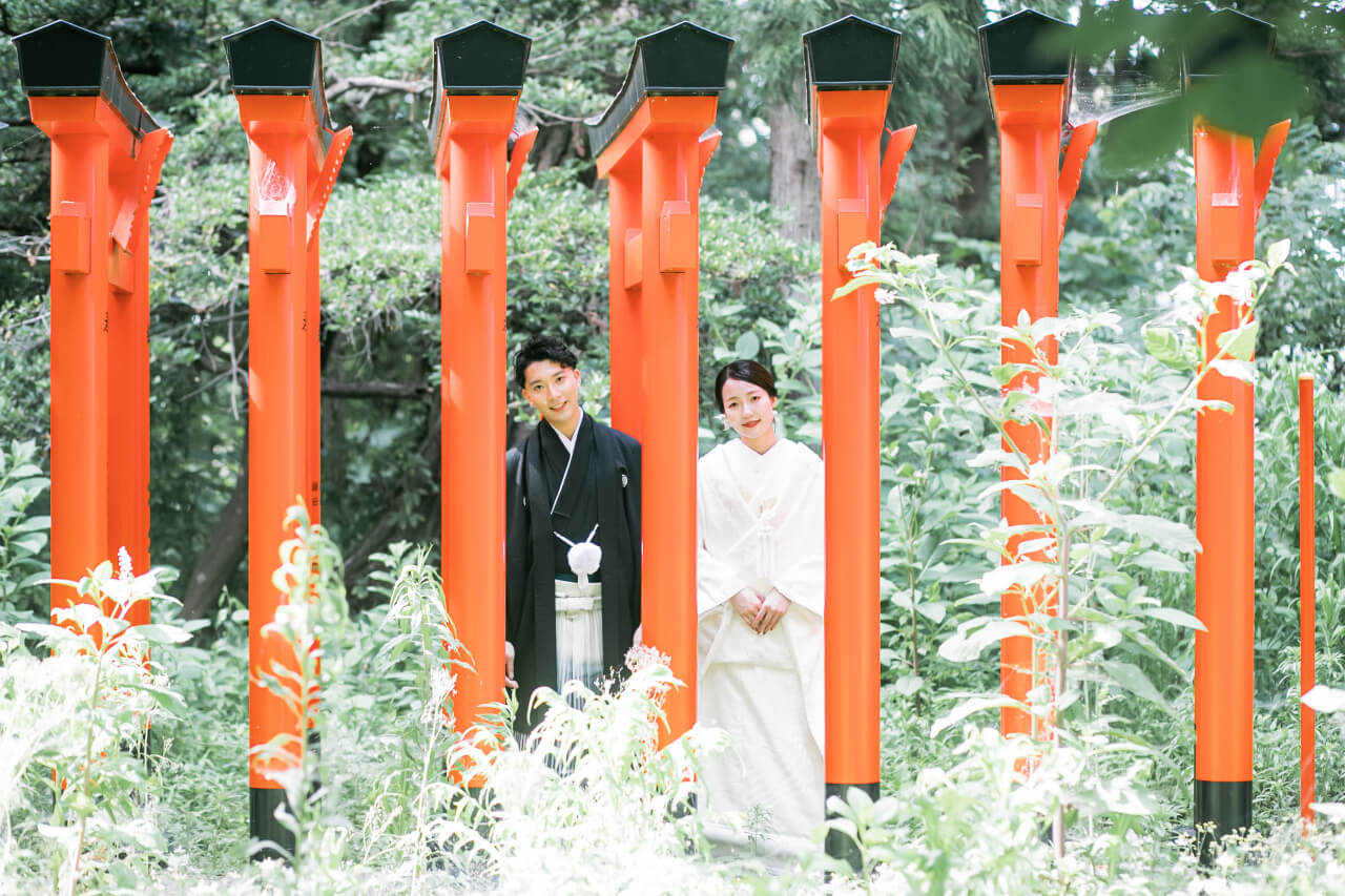 新発田の大友稲荷奥之院で朱色の鳥居を歩く白無垢の花嫁と紋付袴の花婿