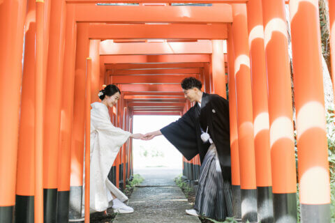 新発田の大友稲荷奥之院で朱色の鳥居を歩く白無垢の花嫁と紋付袴の花婿
